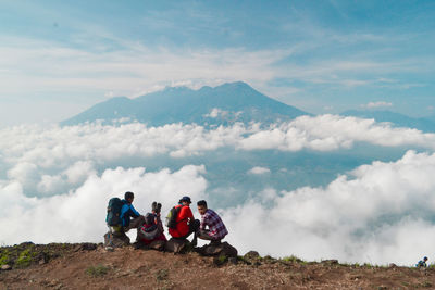 People on mountain against sky