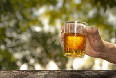 Close-up of hand holding beer glass