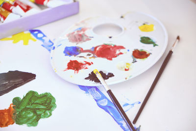 Painting, artist palette and paintbrushes. palette with mixed paints, paintbrush and painting