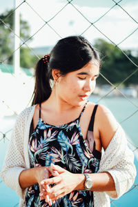 Young woman standing by net in court