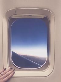 Airplane flying in sky seen through window