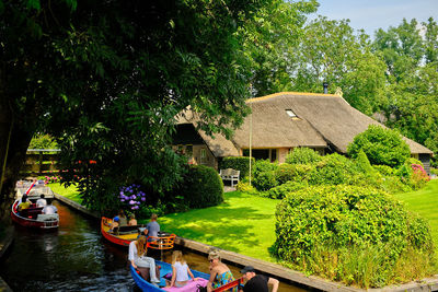 Boats in canal amidst trees and buildings