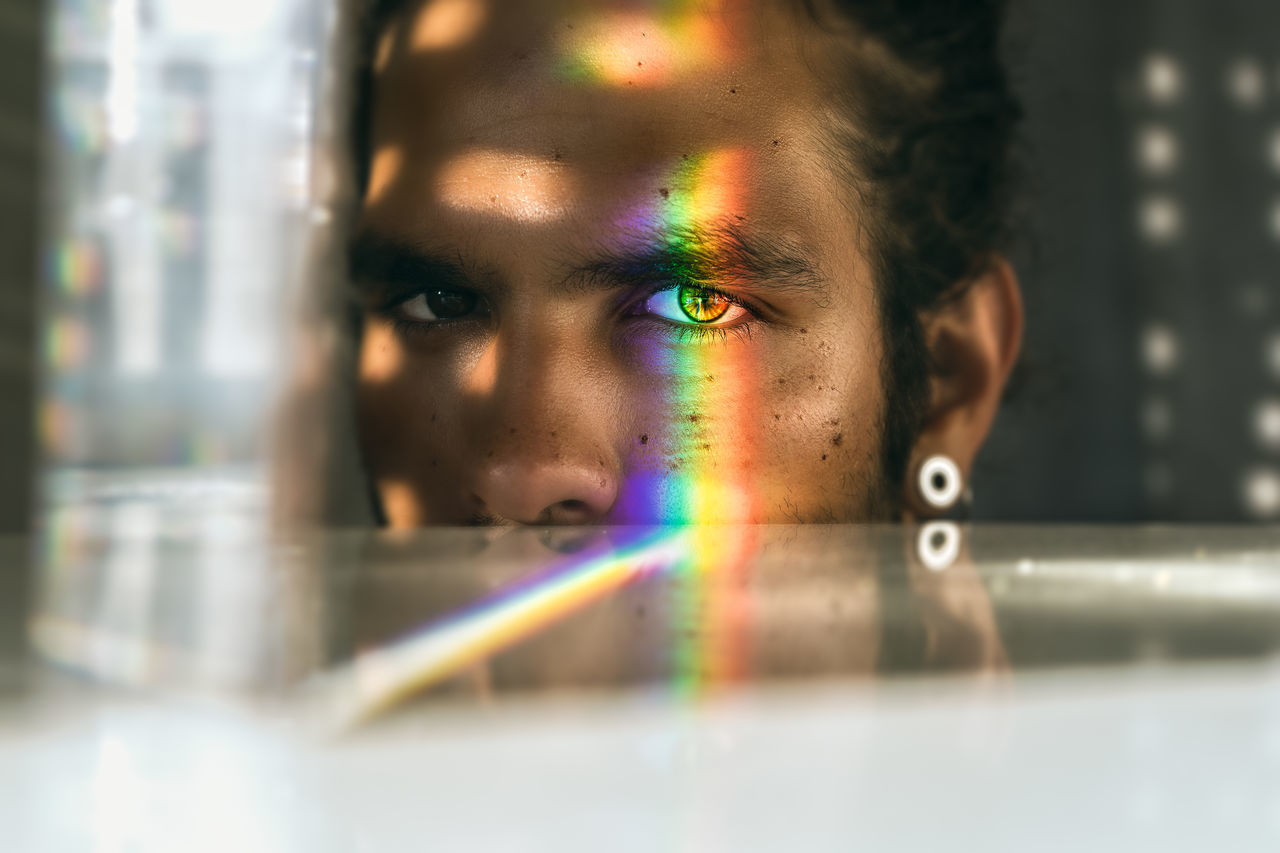 PORTRAIT OF BOY LOOKING AT MULTI COLORED GLASS