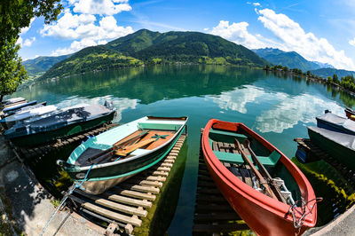 Panoramic view of boats moored in lake against sky