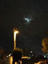 Low angle view of illuminated city against sky at night