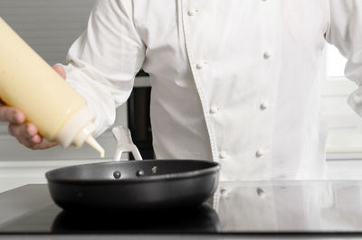 Midsection of man preparing food in kitchen