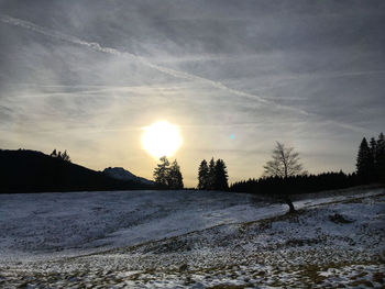 Scenic view of snow covered land against sky during sunset