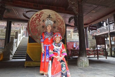 High angle portrait of girl standing against built structure