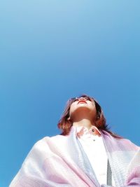 Low angle view of woman against blue sky