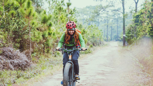 Female hiker riding bicycle in forest