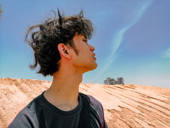 Portrait of man looking away against sky