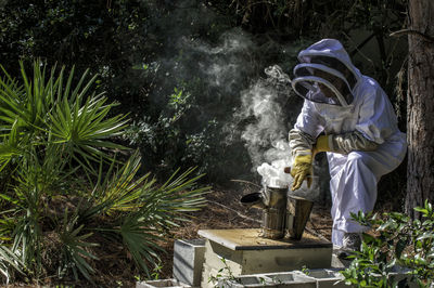 Woman working amdist smoke by plants