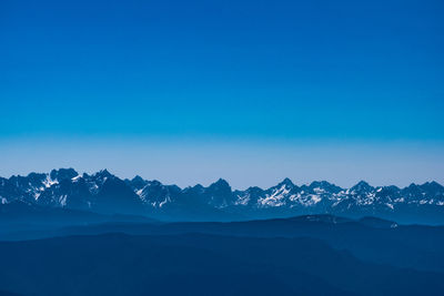 Scenic view of snowcapped mountains against clear blue sky