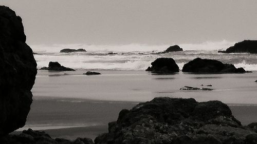 Scenic view of rocks in sea against sky