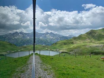 Scenic view of field and mountains against sky