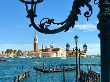 View of boats in canal against cloudy sky