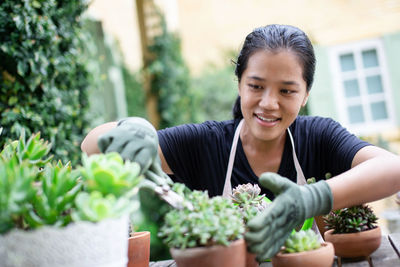 Portrait of a smiling young woman gardening in back yard