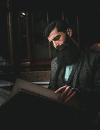 Man reading book while sitting on seat