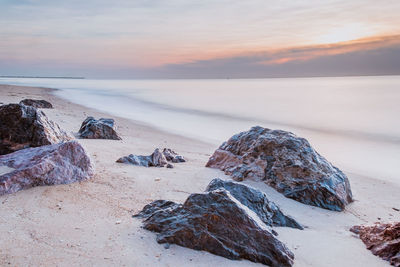 Long exposure sea rocks magnificent sunrise view at sunrise romantic atmosphere in morning at sea. 