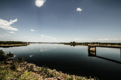 View of calm lake against cloudy sky