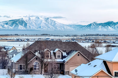 Snow covered houses and buildings against sky