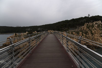 Footbridge over water against sky