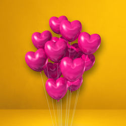 Close-up of multi colored balloons against yellow background