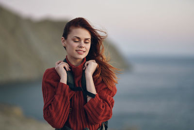 Beautiful young woman looking away while standing in sea