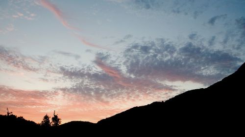 Silhouette of mountain against cloudy sky