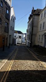 Cobblestone street amidst buildings against sky