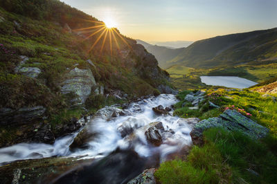 Scenic view of stream against sky during sunset