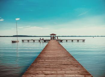 Pier over sea against blue sky