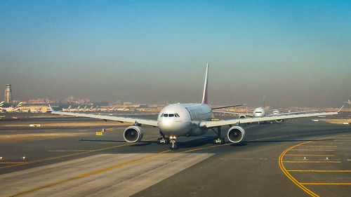 Airplane on runway against sky