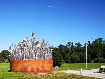 Trees on field against clear blue sky