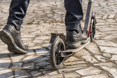 Low section of person with bicycle on footpath