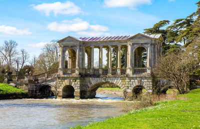 Arch bridge over water against sky