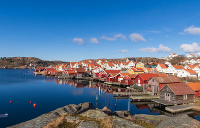 Houses by town against blue sky