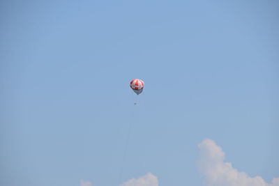 Low angle view of balloons flying against blue sky