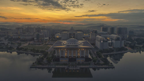 Aerial view of buildings against cloudy sky during sunset