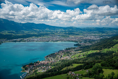 Aerial view of townscape by sea against sky
