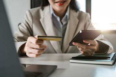 Midsection of businessman using mobile phone