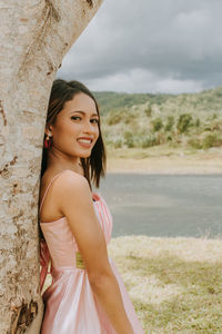 Portrait of a smiling young woman standing on land