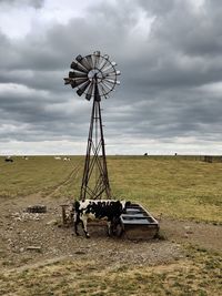 Traditional windmill on field against sky