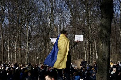 Rear view of people walking in forest during winter