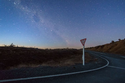 Road amidst landscape against sky at night