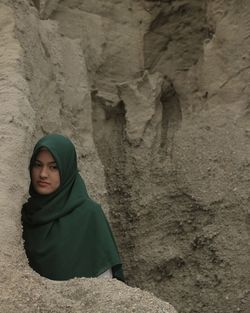 Portrait of hijab woman standing against rock formations