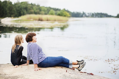 Mother with daughter relaxing at lake