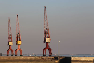 Cranes at construction site against clear sky