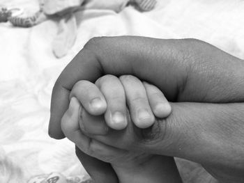 Cropped hands of parent and baby