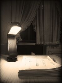 Illuminated lamp on table at home